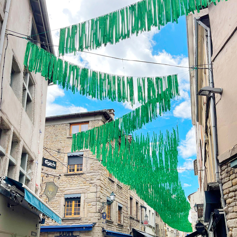 Guirlandes de rubans vertes installées en zig-zag dans la rue